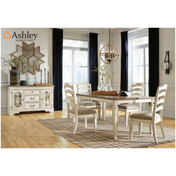 Τραπεζαρία Realyn, της Ashley, με  επεκτεινόμενο τραπέζι και έξι καρέκλες με στρογγυλεμένες σανίδες στην πλάτη σε παλαιωμένο λευκό.