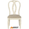 Καρέκλα τραπεζαρίας Realyn της Ashley, με στρογγυλεμένη πλάτη, αφράτο μαξιλάρι καθίσματος και λευκό φινίρισμα παλαιωμένου επίπλου.