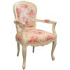 Πολυθρόνα με ξύλινο εμφανή λευκό σκαλιστό σκελετό και διακριτή πλάτη, που είναι επενδεδυμένη με λουλουδάτη ταπετσαρία.