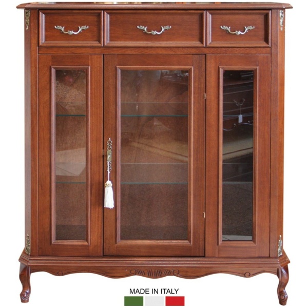 Βιτρίνα ιταλική ξύλινη, με τρία συρτάρια και μία κεντρική πόρτα, με τζάμι, με λιτό μπρούτζινο διάκοσμο και μπρούτζινα χερούλια.