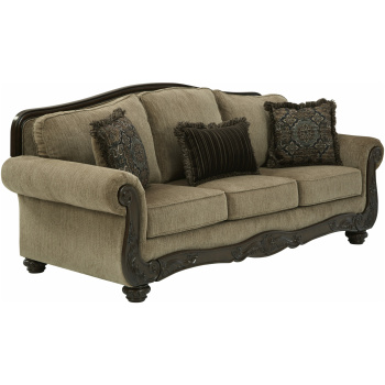 Τριθέσιος καναπές Briaroaks, από την Ashley®. Με σκαλίσματα στον ξύλινο σκελετό και ταπετσαρία σε καφέ-ο-λε χρώμα και τρία διακοσμητικά μαξιλάρια.