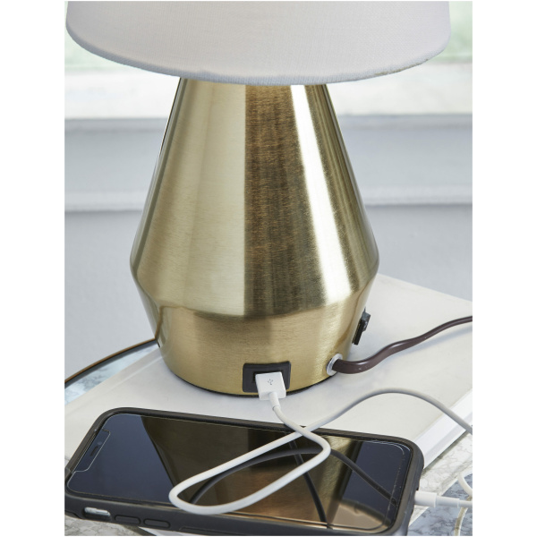 Επιτραπέζιο φωτιστικό Lanry, της Ashley. Διαθέτει μία αστραφτερή μεταλλική βάση, ένα απλό, λευκό, υφασμάτινο καπέλο και μία θύρα USB.