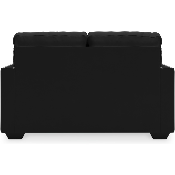 Διθέσιος καναπές Gleston, της Ashley. Έχει βελούδινη ταπετσαρία με χαμηλό πέλος, σε χρώμα μαύρου όνυχα και διακοσμητικούς καμπαράδες στα ερεισίχειρα.
