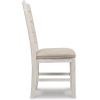 Καρέκλα τραπεζαρίας Skempton, της Ashley, με λευκόγκριζο φινίρισμα, μαξιλαρωτό κάθισμα και λιτό ρουστίκ σχέδιο με κλιμακωτή, ξύλινη πλάτη.
